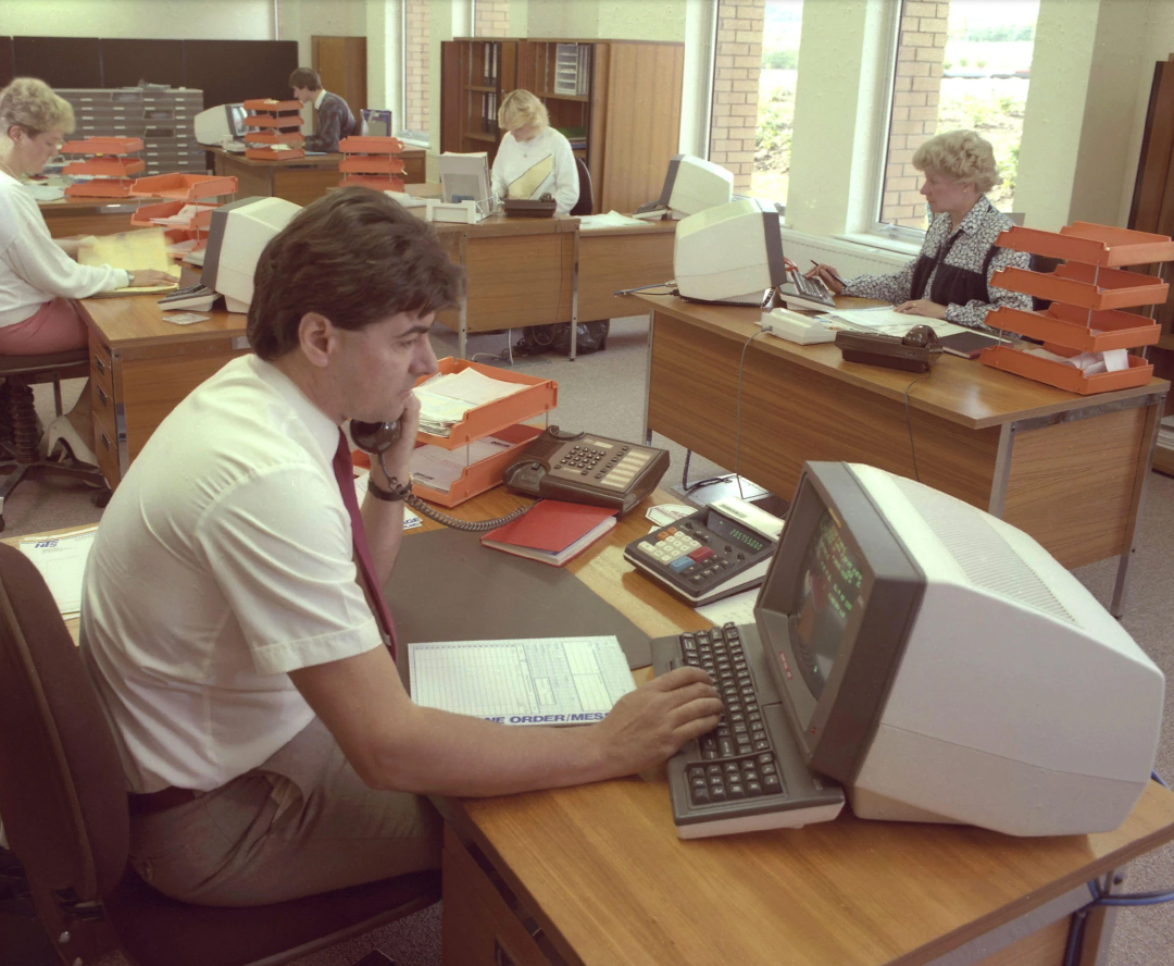 Office workers sitting at work in the early 90s